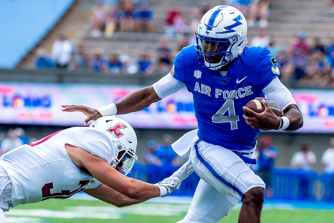 An Air Force cadet dodges a tackle during a football game.