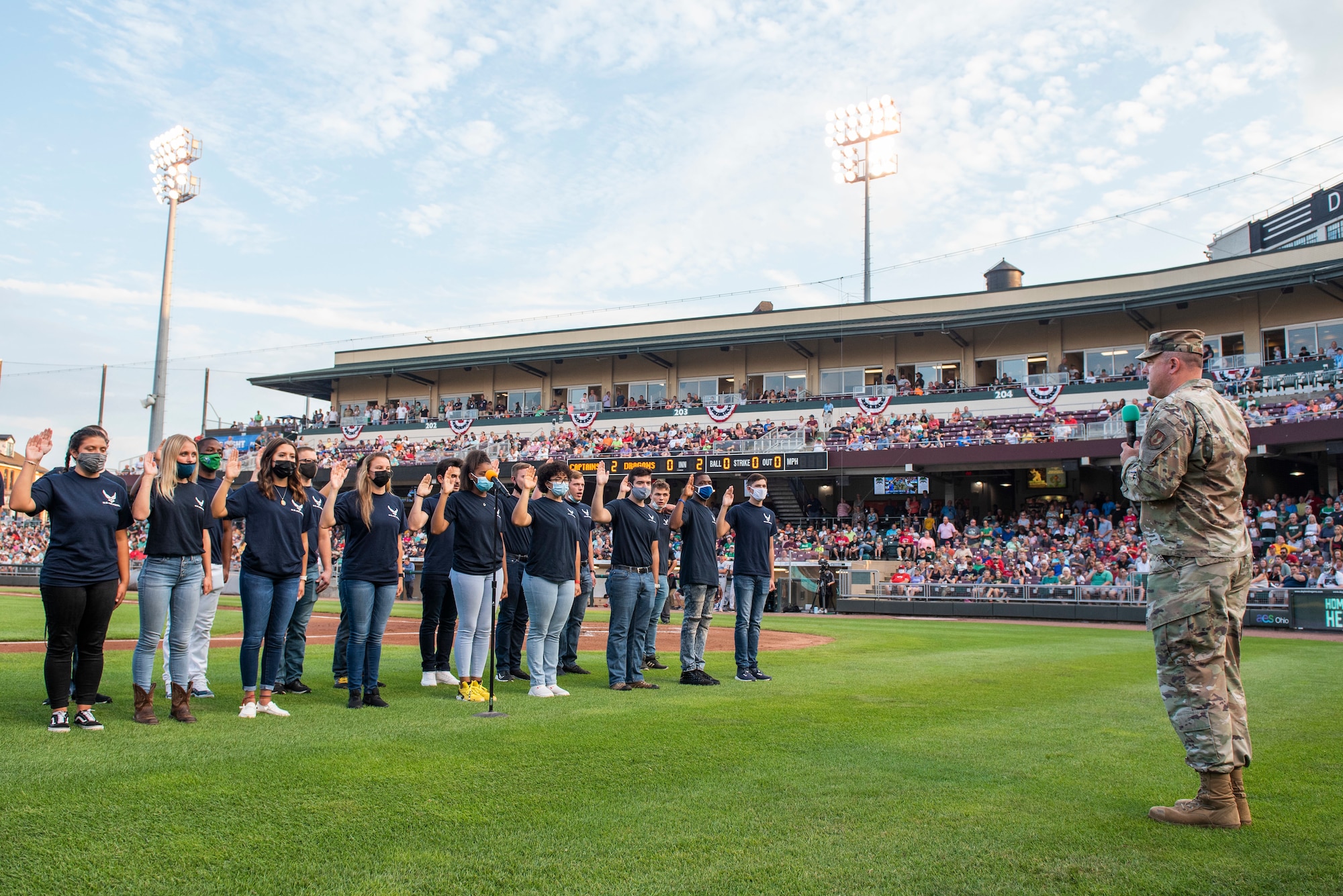 Col. Patrick Miller, 88th Air Base Wing and Wright-Patterson Air Force Base commander, administers the oath of enlistment to 17 individuals from the Delayed Entry Program prior to the Dayton Dragons game Aug. 21 at Day Air Credit Union Ballpark. Miller says social connection on base and within the local community is a key part of Airmen wellness. (U.S. Air Force photo by Wesley Farnsworth)