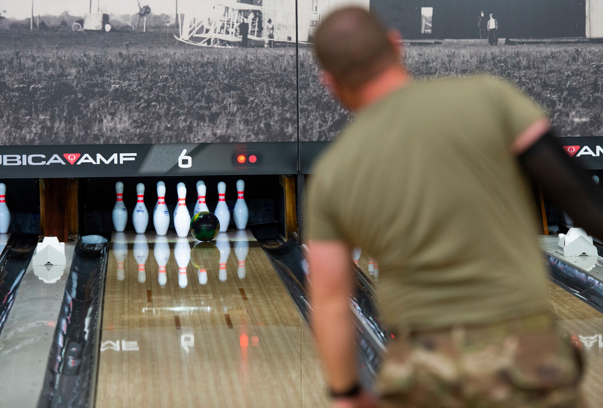 A participant watches as his shot hits the pocket during the Eagles vs. Chiefs Bowling Challenge at Wright-Patterson Air Force Base on April 9. Bowling is among numerous social activities on base that help promote the four domains of overall wellness. (U.S. Air Force photo by Wesley Farnsworth)