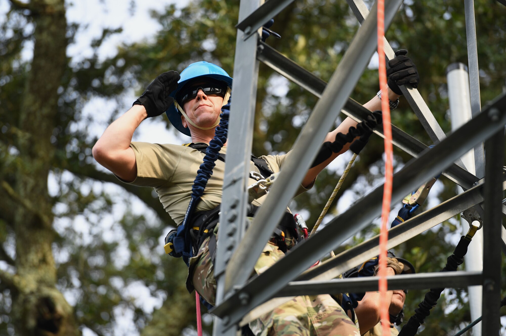 U.S. Air Force Col. William Hunter, 81st Training Wing commander, renders a salute during the playing of the national anthem while participating in a tower climbing demonstration during an 85th Engineering Installation Squadron immersion tour behind Maltby Hall at Keesler Air Force Base, Mississippi, Sept. 1, 2021. The purpose of the tour was to become more familiar with the squadron's mission and its capabilities. (U.S. Air Force photo by Kemberly Groue)