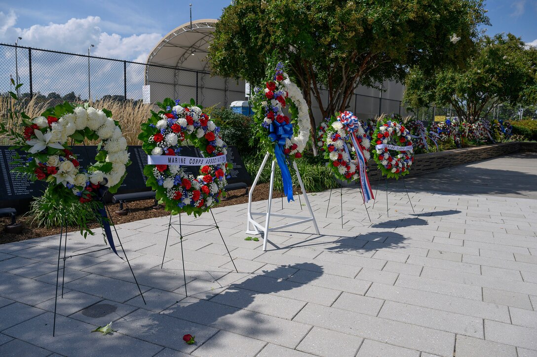 A row of wreaths is displayed in a row outside.