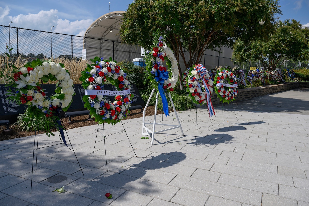 A row of wreaths is displayed in a row outside.