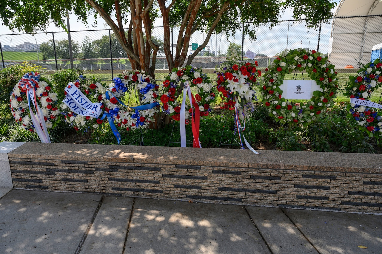 A row of wreaths is displayed in a row outside.