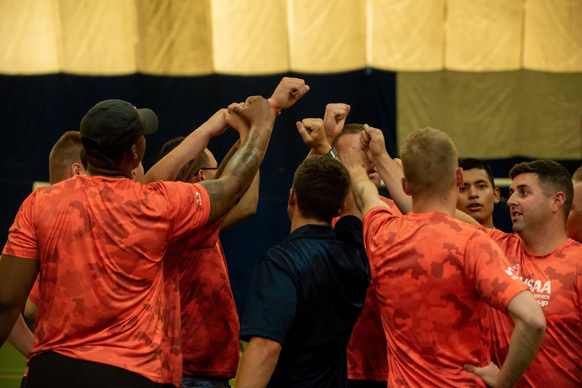 Servicemembers huddle up during a Denver Broncos training camp