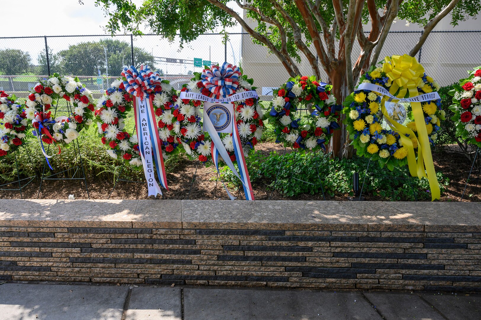 A row of wreaths is displayed in a row outside.
