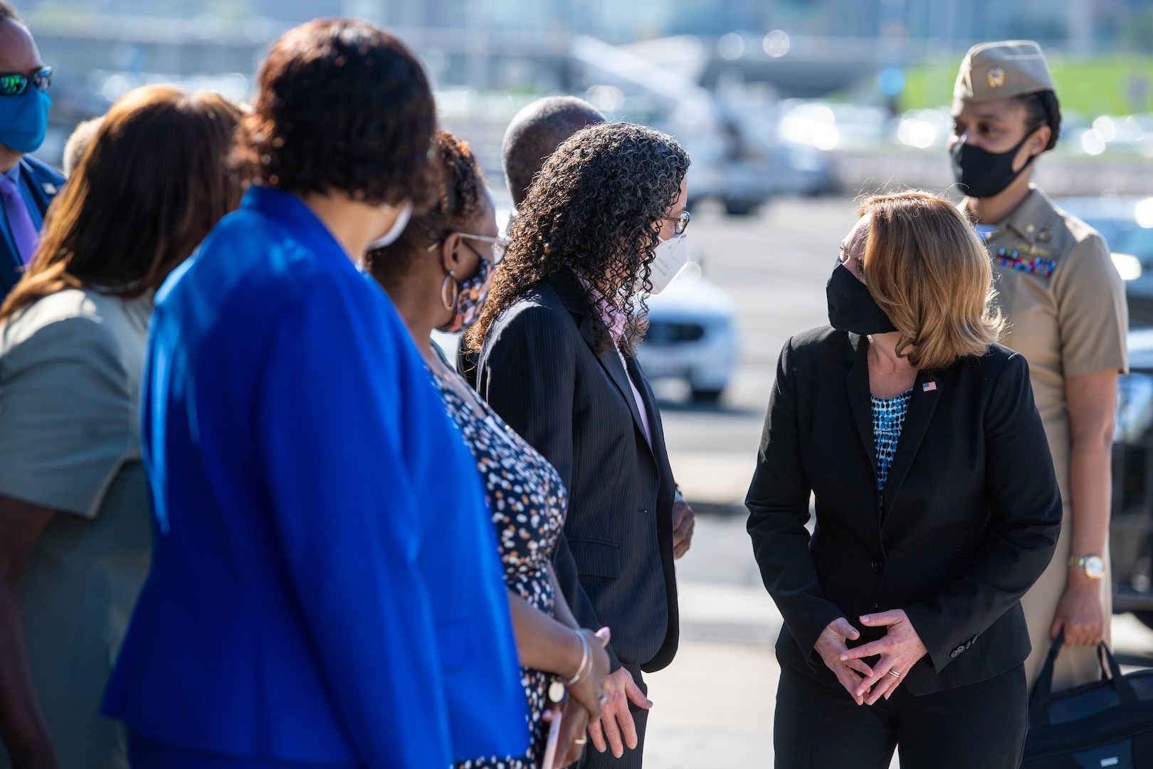 A woman speaks with people at a memorial.
