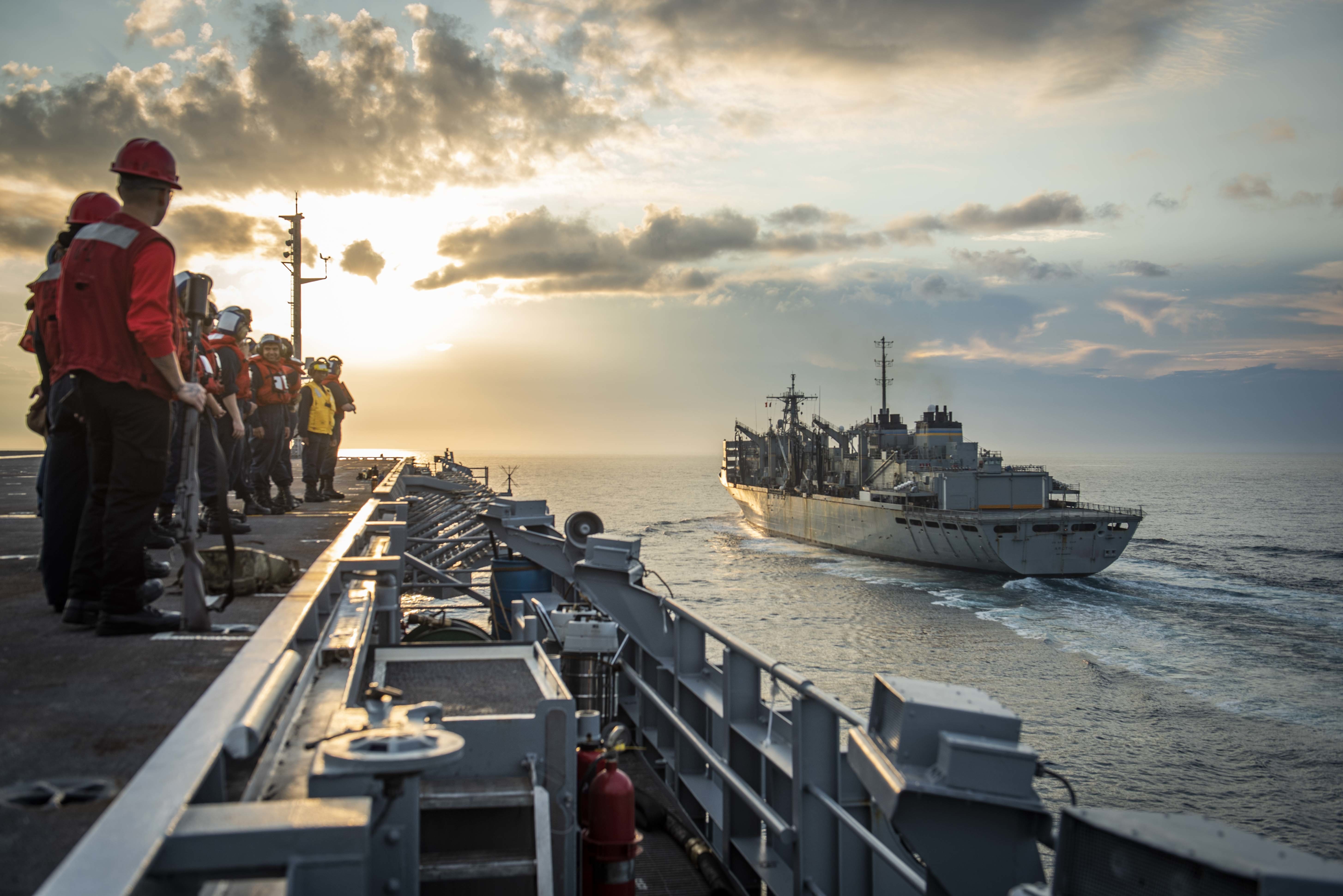 Sailors stand ready as the aircraft carrier USS George H.W. Bush (CVN 77) pulls alongside the fast combat support ship USNS Arctic (T-AOE 8) for a replenishment-at-sea.