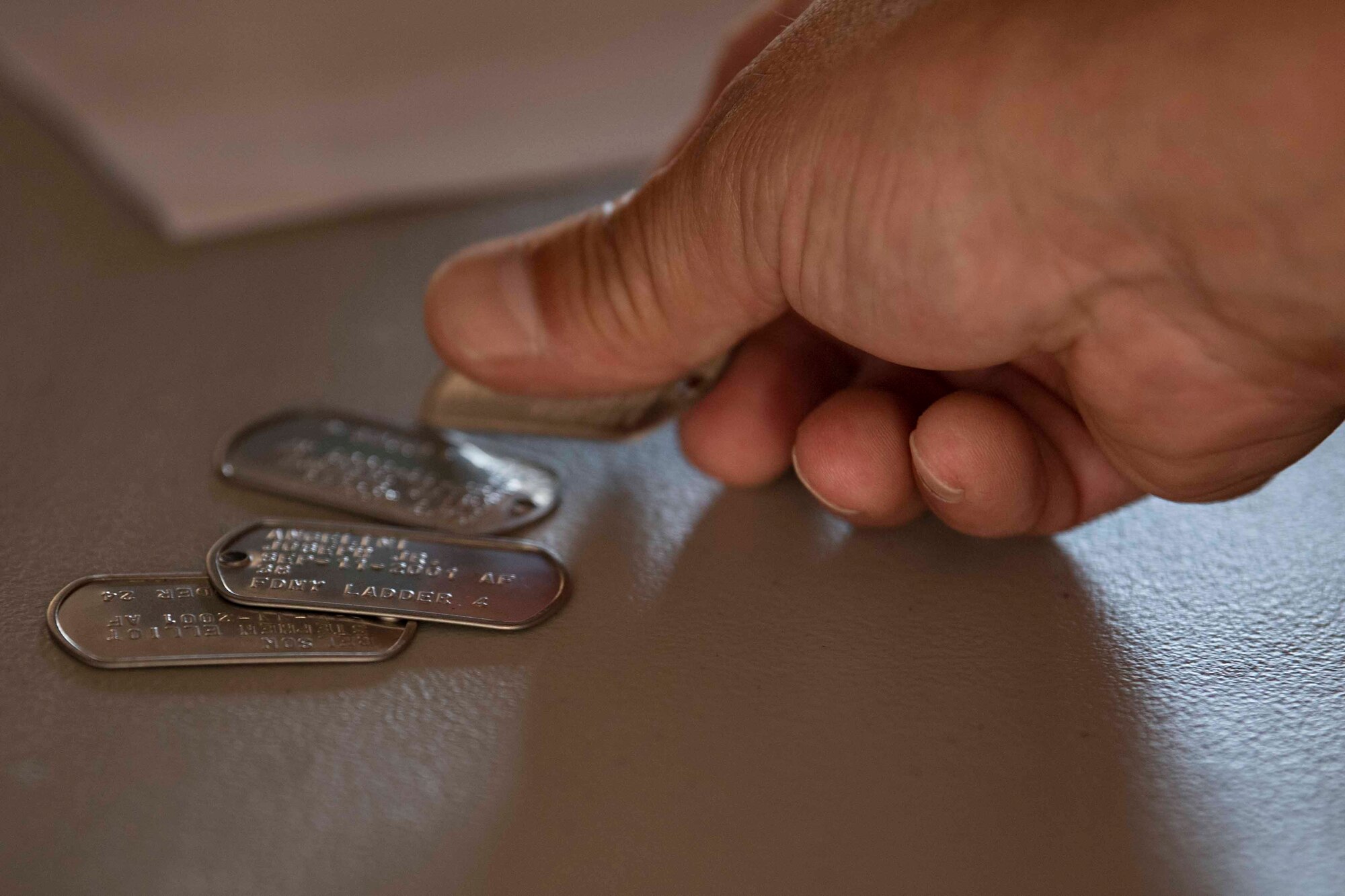 A volunteer for the 10th annual Yokota Fire Emergency 9/11 Tower Run places a dog tag on a table for a participant at Yokota Air Base, Japan, Sept. 10, 2021.