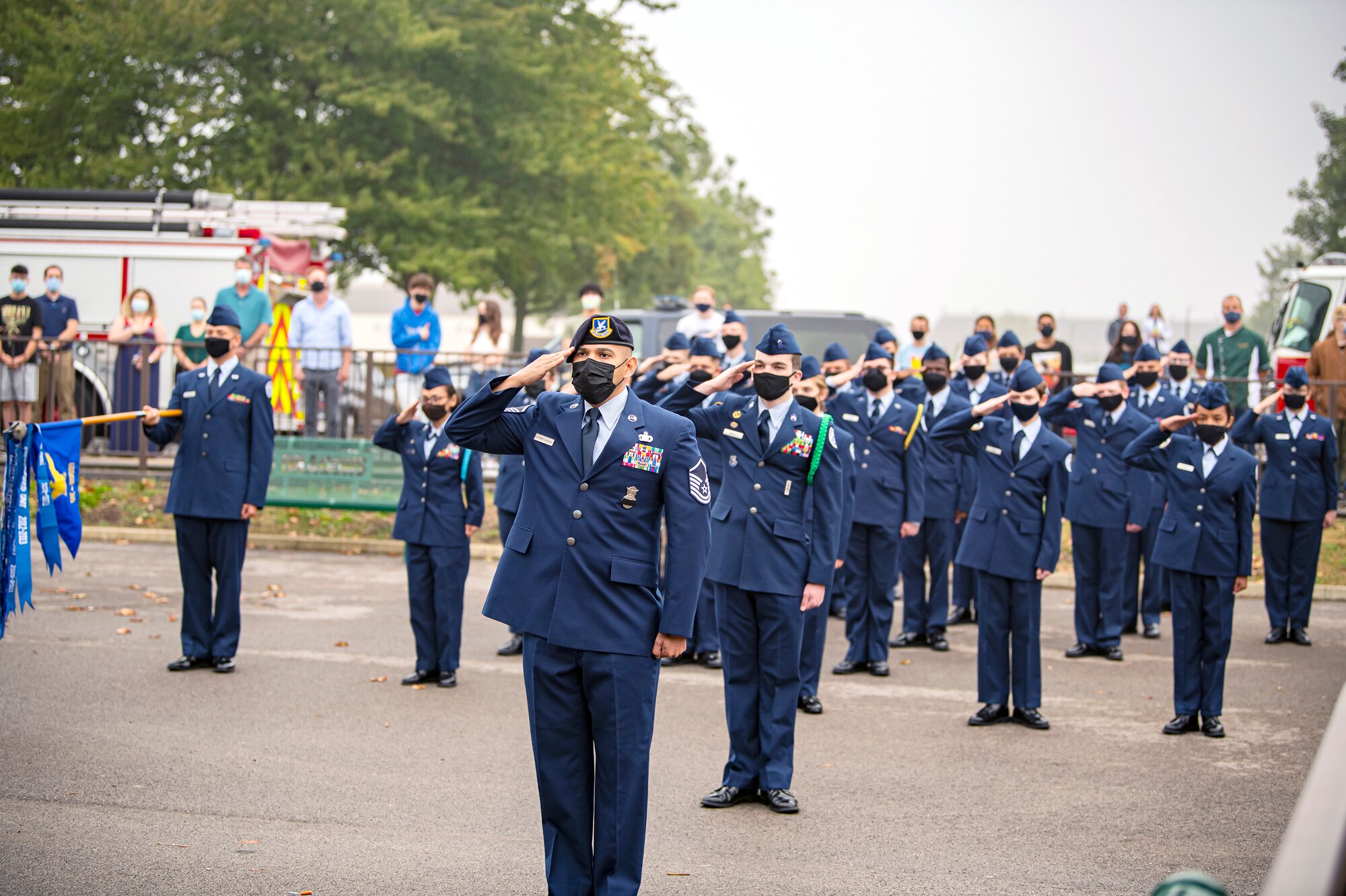 Master Sgt. Christian Navarro-Salazar, front, 423rd Security Forces Squadron supply and logistics superintendent, along with cadets from the Alconbury Middle Highschool JROTC, salute during a 9/11 remembrance ceremony at RAF Alconbury, England, Sept. 9, 2021. Airmen, Cadets and guests came together to pay homage to those who lost their lives during the Sept. 11, 2001, attacks. (U.S. Air Force photo by Senior Airman Eugene Oliver)