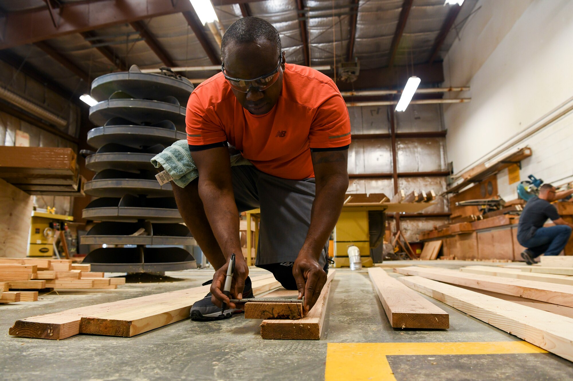 U.S. Air Force Tech Sgt. David Cameron, 8th Civil Engineer Squadron noncommissioned officer in charge of the fuels lab craft, measures refurbished wood planks at Kunsan Air Base, Republic of Korea, Aug 28, 2021. Volunteers from across the Wolf Pack dedicated hours of woodworking, gardening, painting and more to ensure the Kunsan Air Base Legacy Garden was built and dedicated to veterans by Sept 8, 2021.  (U.S. Air Force photo by Staff Sgt. Jesenia Landaverde)