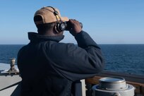 (Sept. 8, 2021) Boatswain’s Mate 2nd Class Anthony Harris stands a lookout watch aboard the Arleigh Burke-class guided-missile destroyer USS Arleigh Burke (DDG 51), Sep. 8, 2021. Arleigh Burke, forward-deployed to Rota, Spain, is on its first patrol in the U.S. Sixth Fleet area of operations in support of U.S. national security interests and regional allies and partners in Europe and Africa.