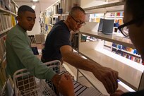 (Sept. 6, 2021) Quartermaster 3rd Class Carlos Paredes, Lt. Carl Scroggs, and Machinist Mate 3rd Class Tai Tran, left to right, assigned to the Arleigh Burke-class guided-missile destroyer USS Arleigh Burke (DDG 51) organize books during a community relations event at the National Library of Estonia while the ship is in port in Tallinn, Estonia, Sept. 6, 2021. Arleigh Burke, forward-deployed to Rota, Spain, is on its first patrol in the U.S. Sixth Fleet area of operations in support of U.S. national security interests and regional allies and partners in Europe and Africa.