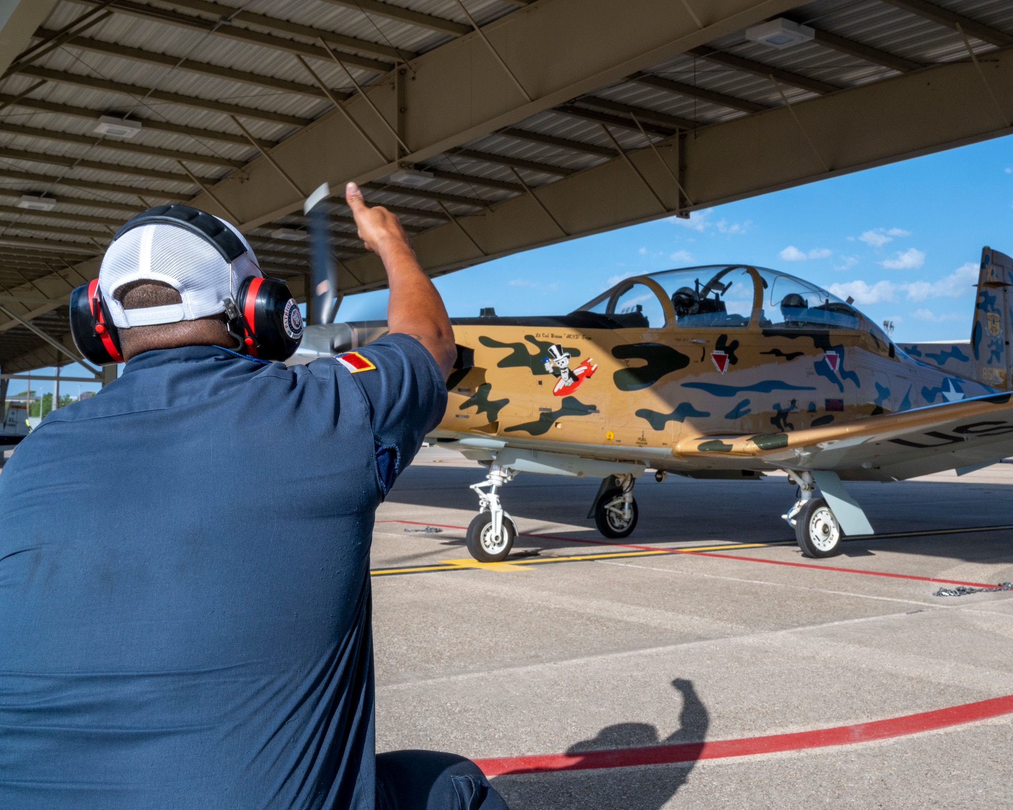 Alex Arriaga, 47th Flying Training Wing crew chief, gives a thumbs up to the pilots as they check the control surfaces of a T-6 Texan II on Laughlin Air Force Base on September 8, 2021. Flight control checks help ensure that the aircraft the pilots are flying will respond in the way they expect. (U.S. Air Force Photo by Senior Airman Nicholas Larsen)