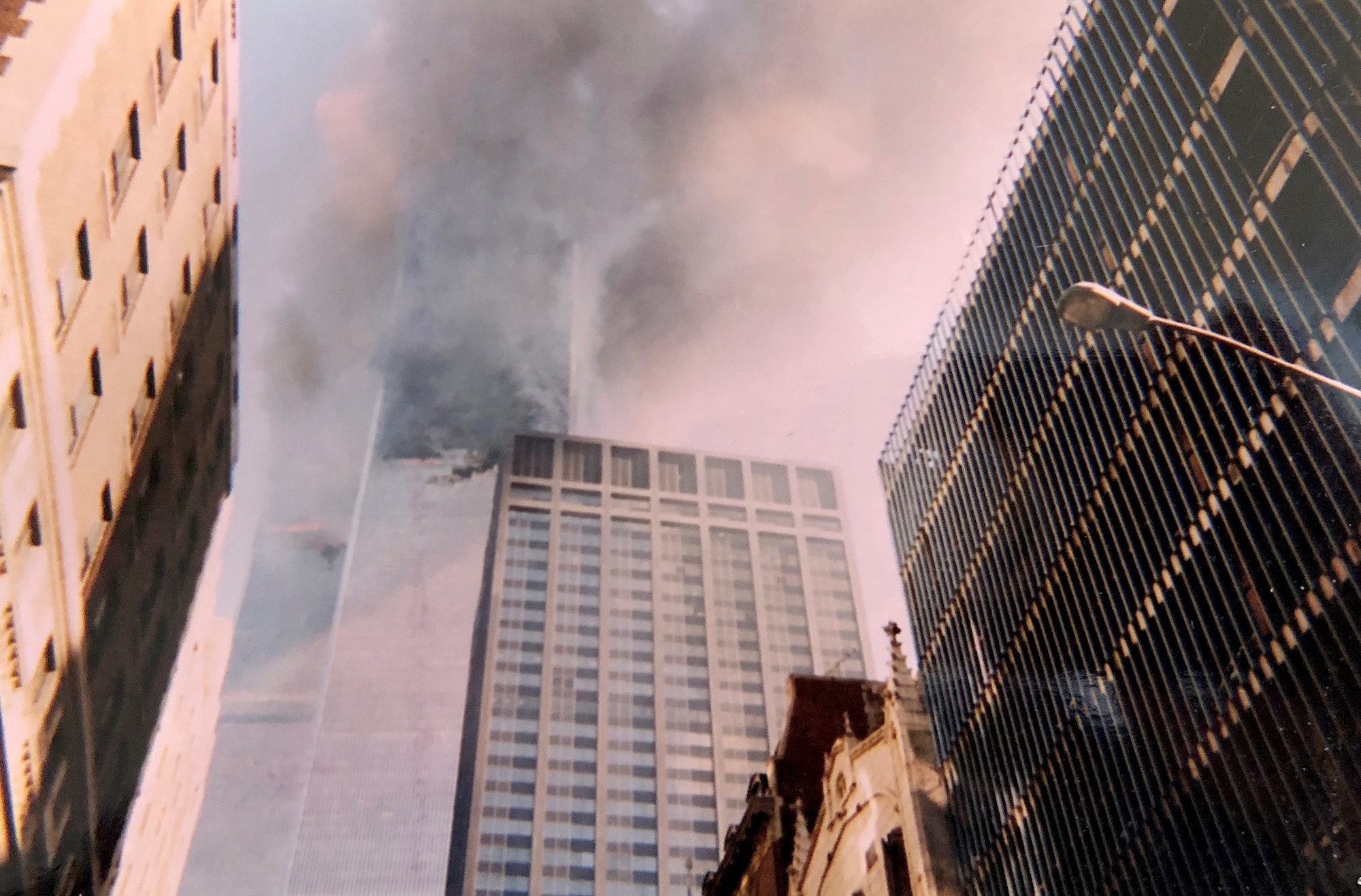 Smoke and flames come from the Twin Towers Sept. 11, 2001, at the World Trade Center, New York City, New York. This photo was captured with a disposable camera purchased specifically to capture events as they unfolded in front of Col. Ephod Shang, vice commander of the 367th Recruiting Group and deputy director at the AFRC Headquarters for Recruiting on Robins AFB, Georgia, when he was a newly minted captain at the time. (Courtesy photo by Col. Ephod Shang)