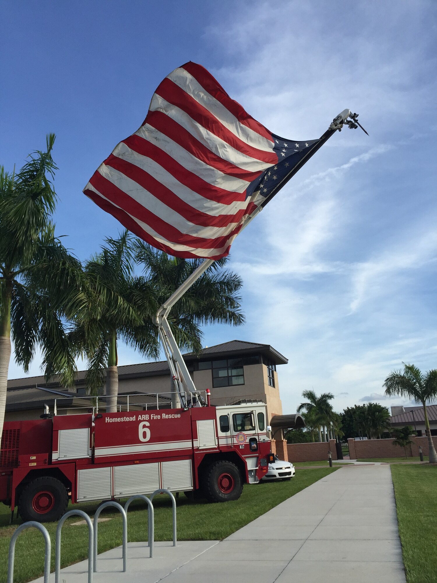 A Homestead Air Reserve Base Fire Department truck displays a large gallantly waving flag outside the HARB Community Activities Center during a 9/11 Remembrance Ceremony event on Sept. 12, 2015. (USAF photo)