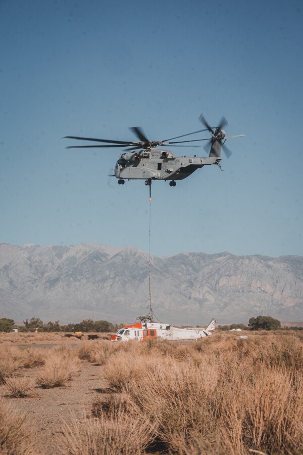 A Marine Corps CH-53K King Stallion lowers a Navy MH-60S Knighthawk Helicopter to the ground after recovering it from the nearby mountain ranges after it conducted a hard landing near, Bishop, California, Sept. 5, 2021. The two day operation was the first official fleet mission for the CH-53K King Stallion, as it is currently undergoing an operational assessment while the Marine Corps modernizes and prepares to respond globally to emerging crises or contingencies. (U.S. Marine Corps photo by Lance Cpl. Colton Brownlee)