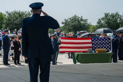 Air Force Honor Guard members fold the U.S. flag during the interment of retired Col. Richard E. Cole.