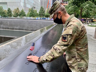 Army Gen. Daniel Hokanson, chief, National Guard Bureau, places a flag and pauses to remember U.S. Military Academy classmate Douglas Gurian, among the almost 3,000 names engraved in the 9/11 Memorial. “It was an attack on our nation, and deeply personal to so many of us,” Hokanson said. The National Guard transformed from a strategic reserve to an operational force after the Sept. 11, 2001, attacks. This image was acquired using a cellular device.