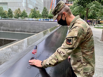 Army Gen. Daniel Hokanson, chief, National Guard Bureau, places a flag and pauses to remember U.S. Military Academy classmate Douglas Gurian, among the almost 3,000 names engraved in the 9/11 Memorial. “It was an attack on our nation, and deeply personal to so many of us,” Hokanson said. The National Guard transformed from a strategic reserve to an operational force after the Sept. 11, 2001, attacks. This image was acquired using a cellular device.