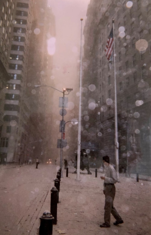 People walk in a dust and debris-filled street after the collapse of the first Twin Tower and look towards the fire coming from the second on Sept. 11, 2001, in front of the World Trade Center, New York City, New York. Col. Ephod Shang, vice commander of the 367th Recruiting Group and deputy director at the AFRC Headquarters for Recruiting on Robins AFB, Georgia, and others were hiding behind a random structure when the first tower fell, the dust completely blocked their vision.