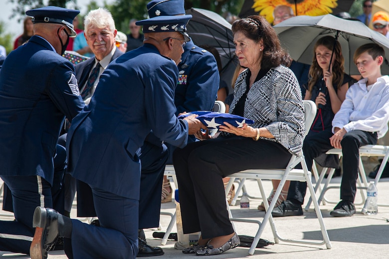 Air Force Chief of Staff Gen. CQ Brown Jr. presents the U.S. flag to retired Col. Richard E. Cole's daughter, Cindy Chal, during his interment ceremony.