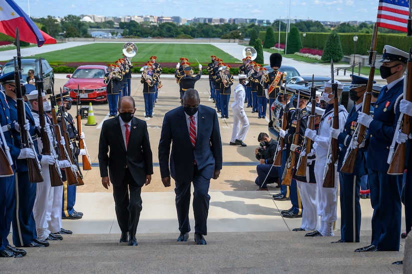 Two men walk past a military honor guard.