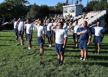 Airmen salute during a 9/11 memorial ceremony at Joint Base Anacostia-Bolling, Washington D.C. on Sept. 10, 2021. The Airmen ran across the base and along the Potomac River waterfront while carrying a specially-designed baton and flag to kick off a 24-hour memorial run and walk event. Mission partners from across the National Capitol Region gathered at JB Anacostia-Bolling to honor those who died 20 years ago during the terror attacks on the World Trade Center and the Pentagon on September 11, 2001. (U.S. Air Force photo by Staff Sgt. Kayla White)