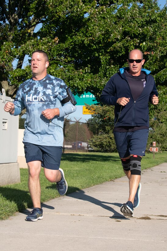 Chief Master Sgt. David Teets, left, 436th Aerial Port Squadron chief enlisted manager, and Chief Master Sgt. Ronely Rivera-Ortiz, 436th Aerial Port Squadron  superintendent, approach the finish line during the “I’ve Got Your Six” 5k at Dover Air Force Base, Delaware, Sept. 10, 2021. Some participants were encouraged to run in pairs while each held a cord, encouraging people to finish together. (U.S. Air Force photo by Mauricio Campino)