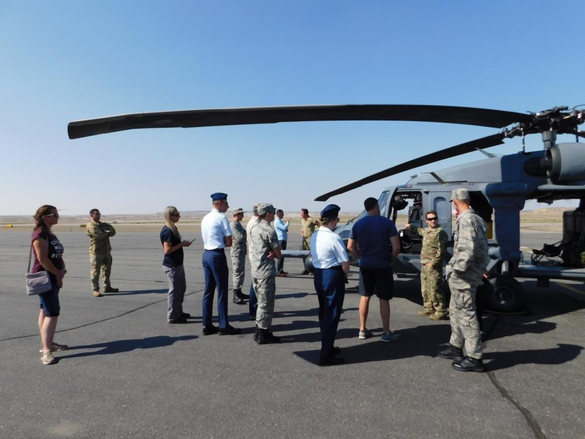 Air Force helicopter pilots speaks to people near HH-60G Pave Hawk.