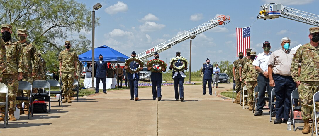 U.S. Air Force members assigned to the 17th Training Wing carry memorial wreaths during a 9/11 memorial ceremony at the Firefighter Memorial Troop Walk, on Goodfellow Air Force Base, Texas, Sept. 8, 2021. The red wreath represented the fire service and the bloodshed in the fight to save our own, the blue wreath represented the vastness it took to manage the events of 9/11, and the white wreath represented emergency medical community and all other partners and the purity of their efforts. (U.S. Air Force photo by Senior Airman Abbey Rieves)