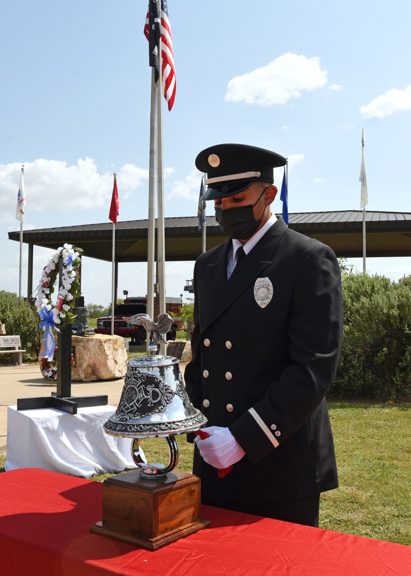 Lance Sauceda, City of San Angelo firefighter and paramedic, conducts the fireman’s bell ringing at a 9/11 memorial ceremony at the Firefighter Memorial Troop Walk, on Goodfellow Air Force Base, Texas, Sept. 8, 2021. The bell was rung five times, which symbolized that a fallen firefighter’s duties are over and charges living firefighters to take on the duty of protecting those left behind. (U.S. Air Force by Senior Airman Abbey Rieves)