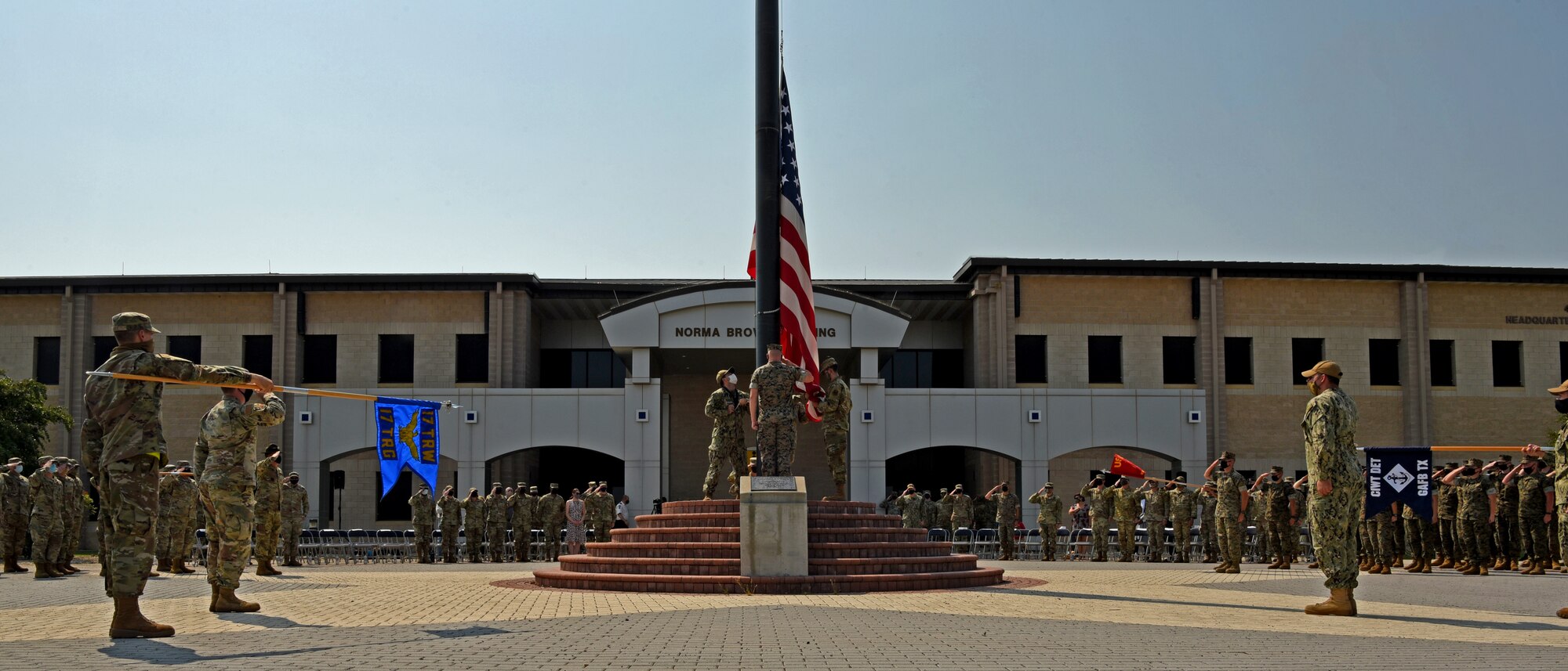 Joint Service Color Guard members lower the U.S. flag during the Retreat Ceremony outside of the Norma Brown building on Goodfellow Air Force Base, Texas, Sept. 10, 2021 The event paid tribute to commemorate the 20th anniversary of those lost during the attacks on 9/11. (U.S. Air Force photo by Senior Airman Abbey Rieves)