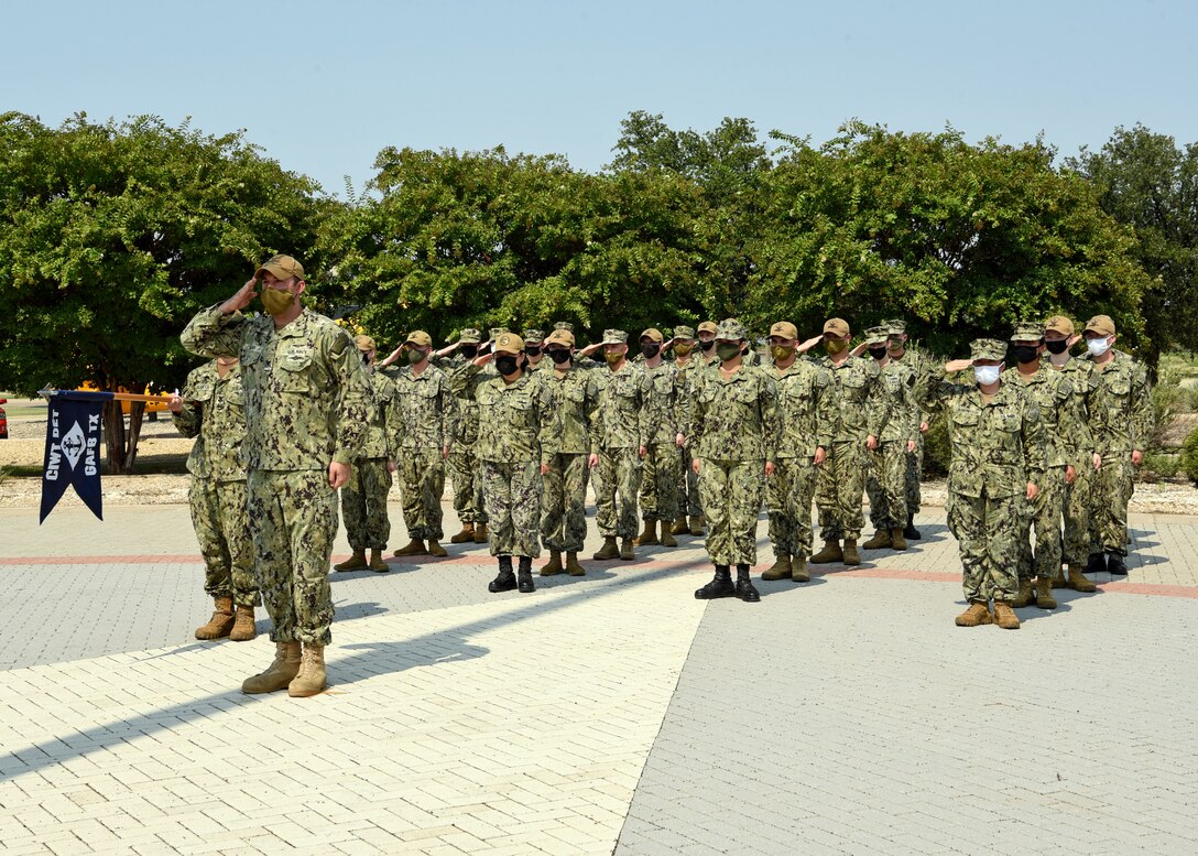 U.S. Navy Petty Officer 1st Class Jordan Allan, Center for Information Warfare Training Detachment Goodfellow instructor, and detachment representatives, pay their tributes during the Retreat Ceremony outside of the Norma Brown building on Goodfellow Air Force Base, Texas, Sept. 10, 2021. The 17th Training Wing along with representatives from the joint services remembered the lives lost on Sept. 11, 2001. (U.S. Air Force Photo by Senior Airman Abbey Rieves)
