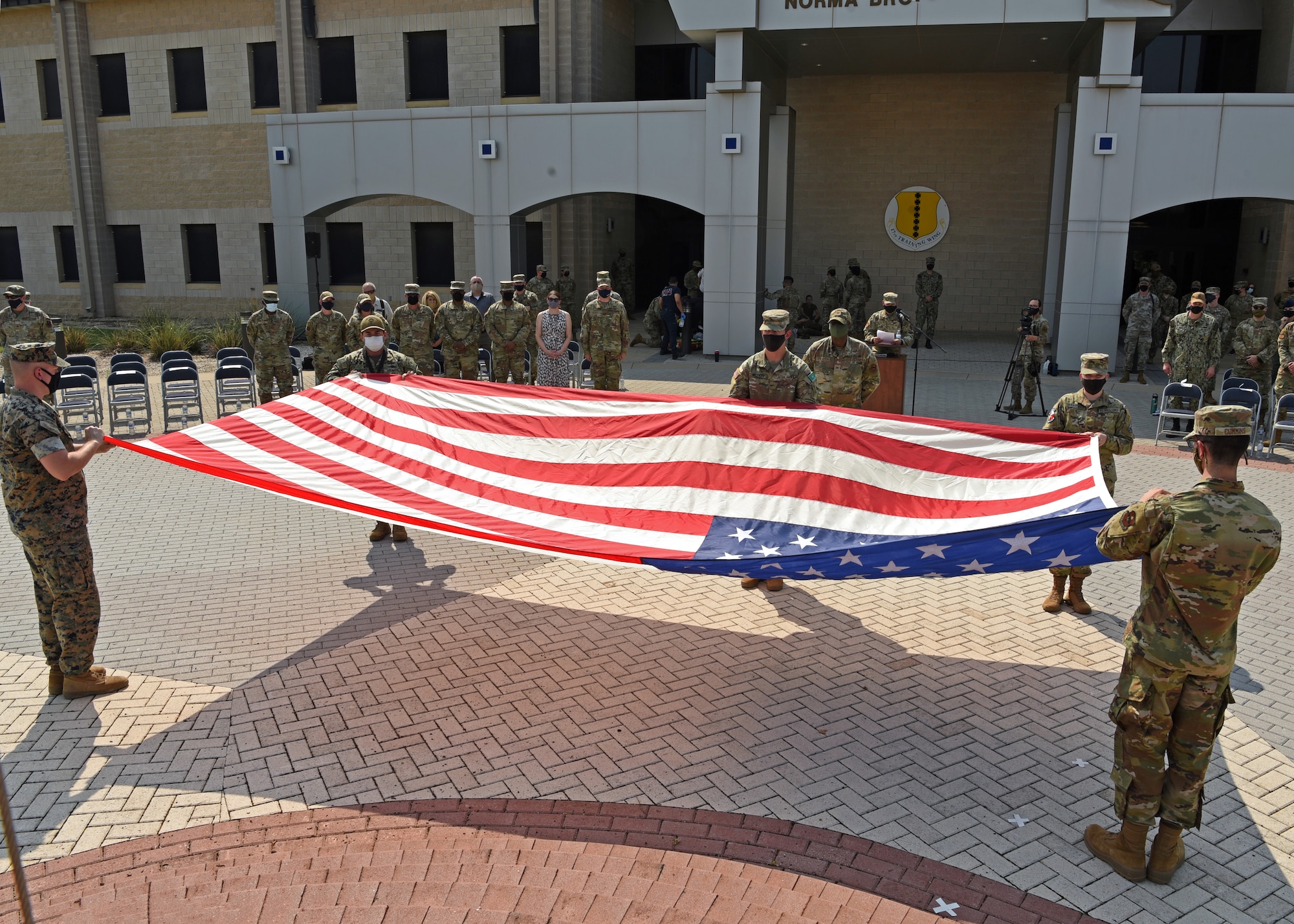 Joint Service Color Guard members fold the U.S. flag at the Retreat Ceremony outside of the Norma Brown building on Goodfellow Air Force Base, Texas, Sept. 10, 2021. Nearly 3,000 people were killed in the collapse of the World Trade Center in 2001. (U.S. Air Force Photo by Senior Airman Abbey Rieves)