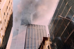 Smoke and flames come from the Twin Towers Sept. 11, 2001, at the World Trade Center, New York City, New York. This photo was captured with a disposable camera purchased specifically to capture events as they unfolded in front of Col. Ephod Shang, vice commander of the 367th Recruiting Group and deputy director at the AFRC Headquarters for Recruiting on Robins AFB, Georgia, when he was a newly minted captain at the time. (Courtesy photo by Col. Ephod Shang)