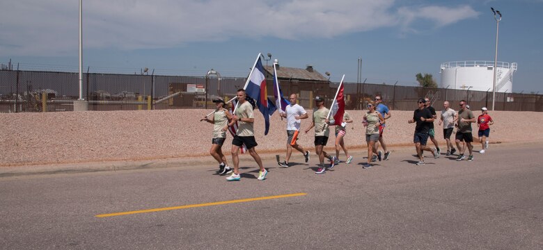 Runners carry flags recognizing fallen service members
