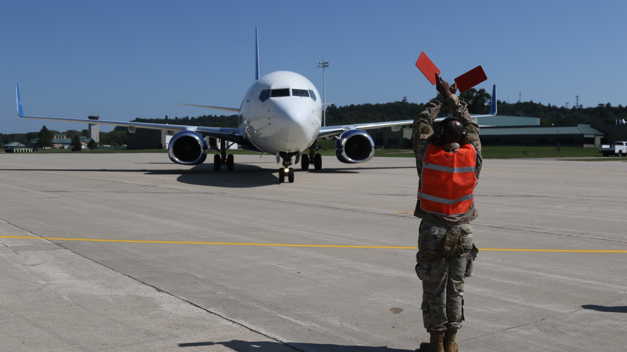 An aircraft transporting Afghans is guided at Volk Field on Camp Douglas Wisconsin, Aug. 22, 2021. The Department of Defense approved a request for assistance from the State Department to provide temporary housing, sustainment, and support inside the United States for vulnerable Afghans at Fort McCoy, Wisconsin, and other facilities around the United States where they and their families can finalize their immigration processing safely.