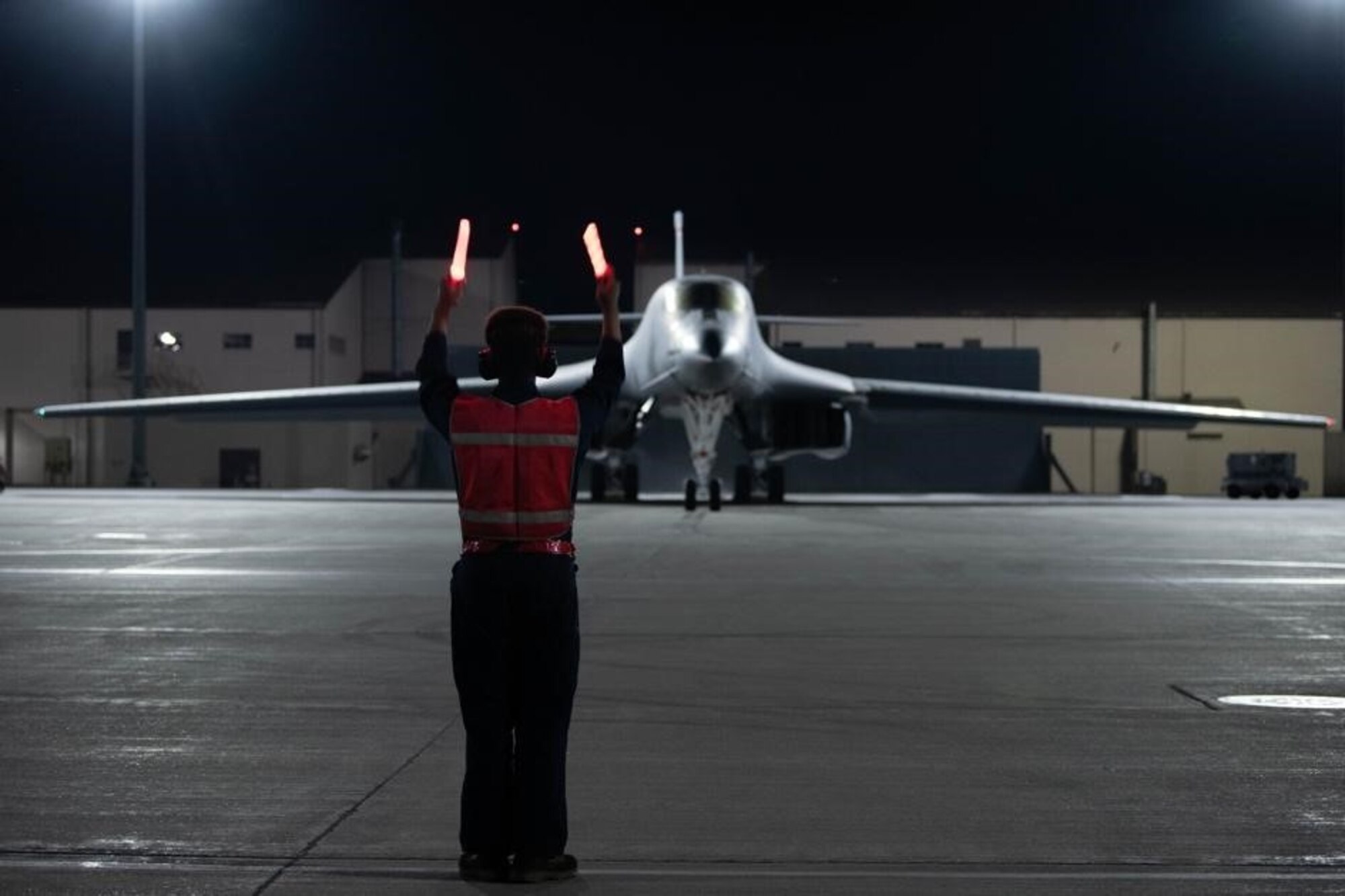 A crew chief assigned to the 28th Aircraft Maintenance Squadron marshals a B-1B Lancer from the tarmac to participate in a Bomber Task Force mission at Ellsworth Air Force Base, S.D., Sept. 7, 2021.