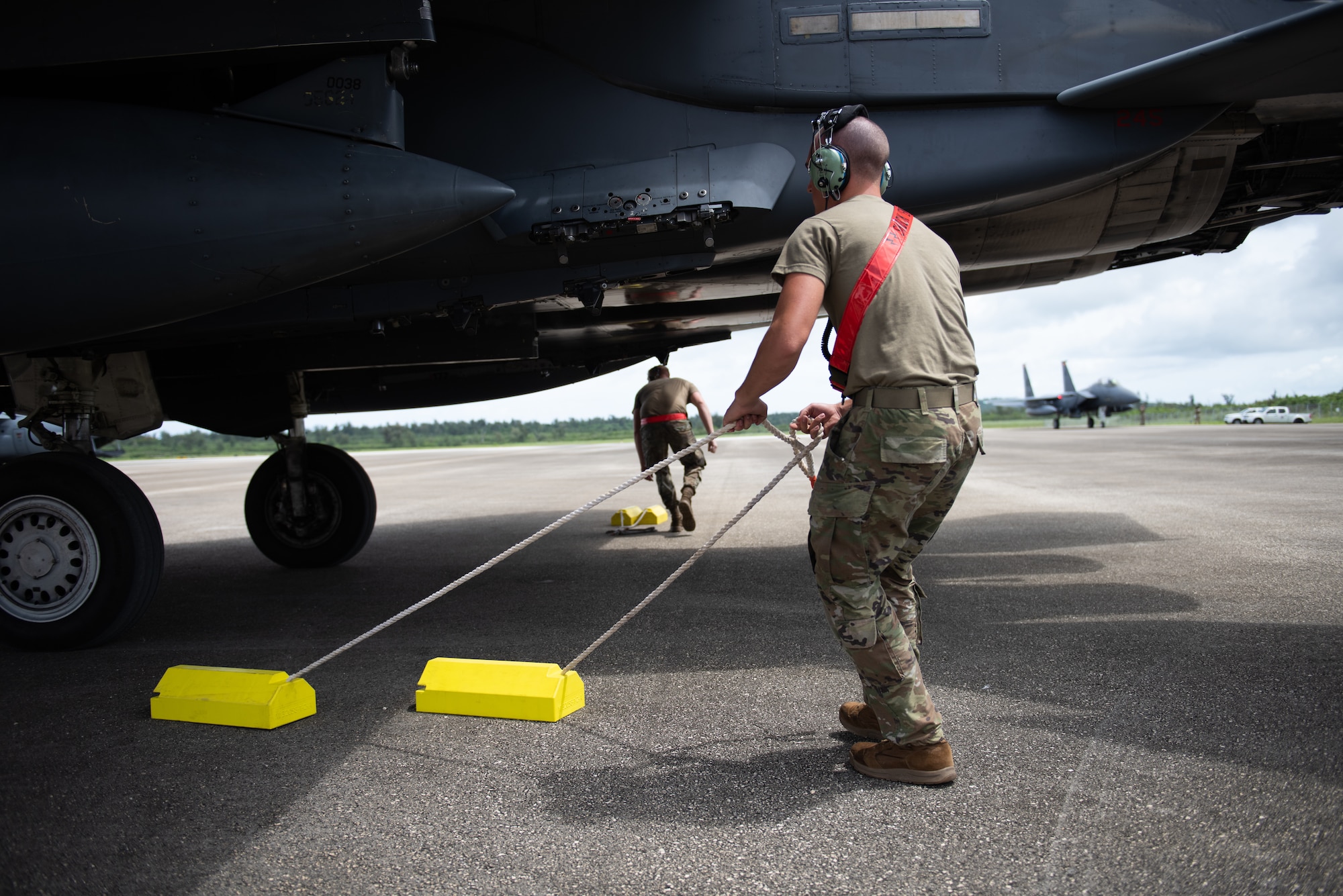 A U.S. Air Force Airmen pulls yellow chocks from underneath an F-15E Strike Eagle