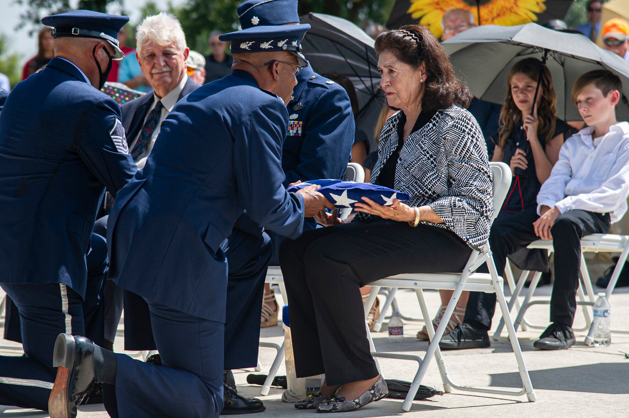 Air Force Chief of Staff Gen. CQ Brown Jr. presents the U.S. flag to retired Col. Richard E. Cole’s daughter, Cindy Chal, during his interment ceremony.