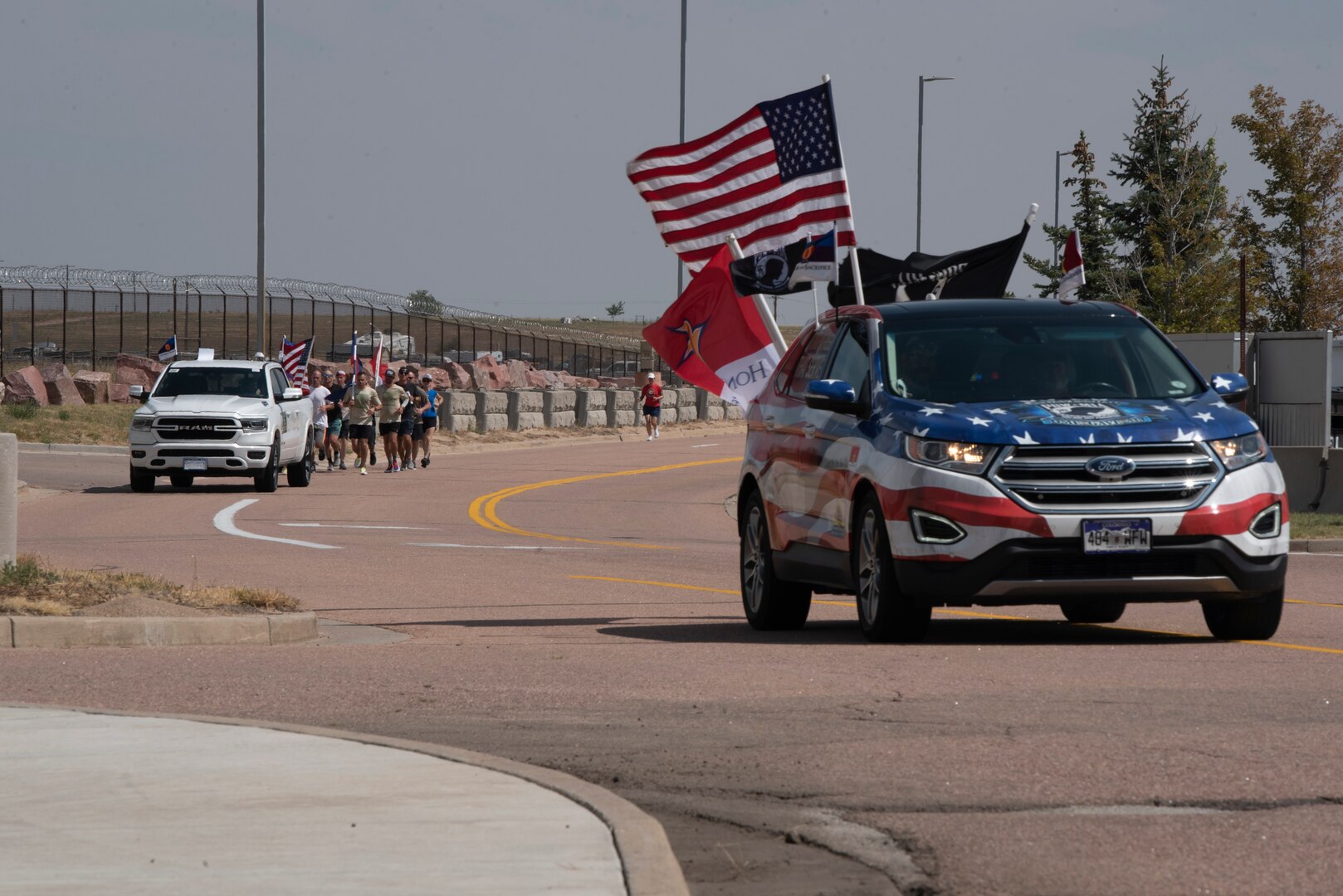 Police escort runners during event honoring fallen service members