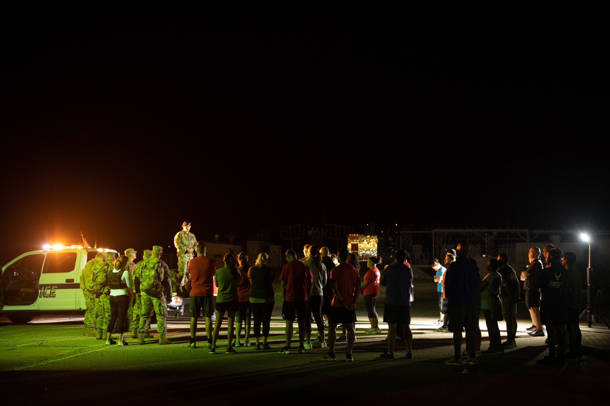 A group of Airmen walk and run outside in an event.