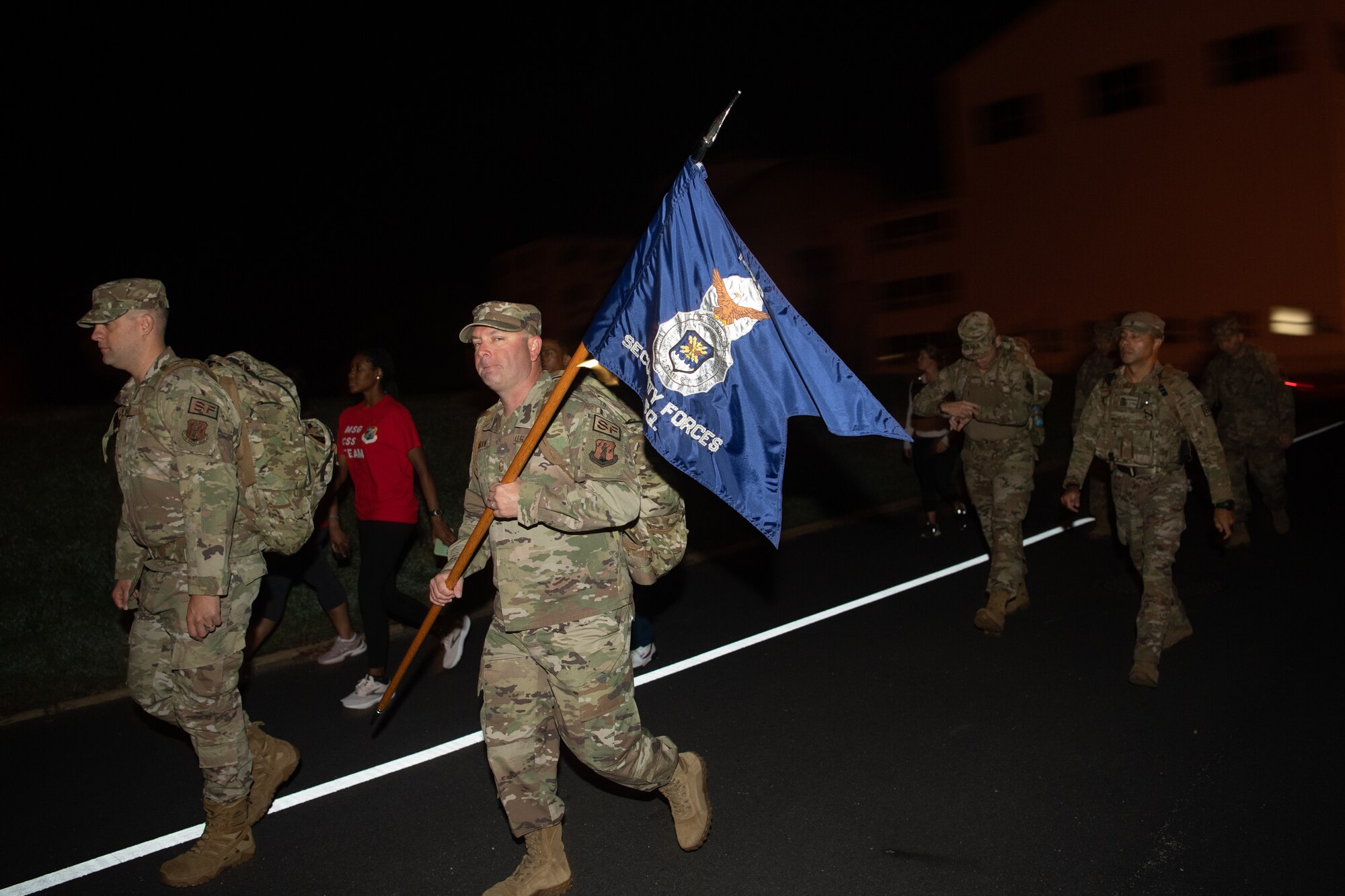 A group of Airmen walk and run outside in an event.