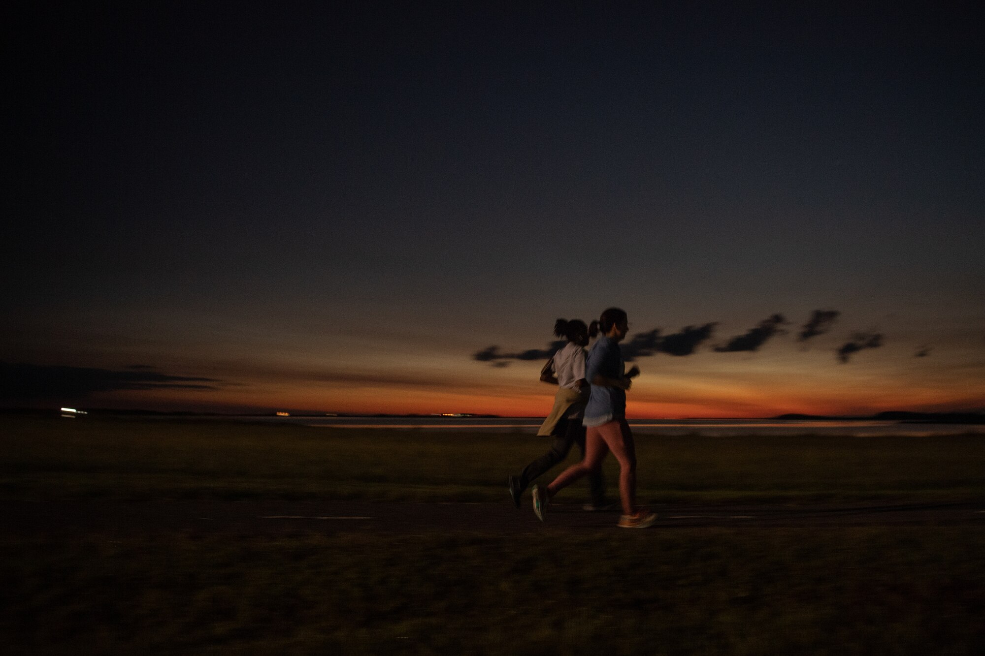 A group of Airmen walk and run outside in an event.