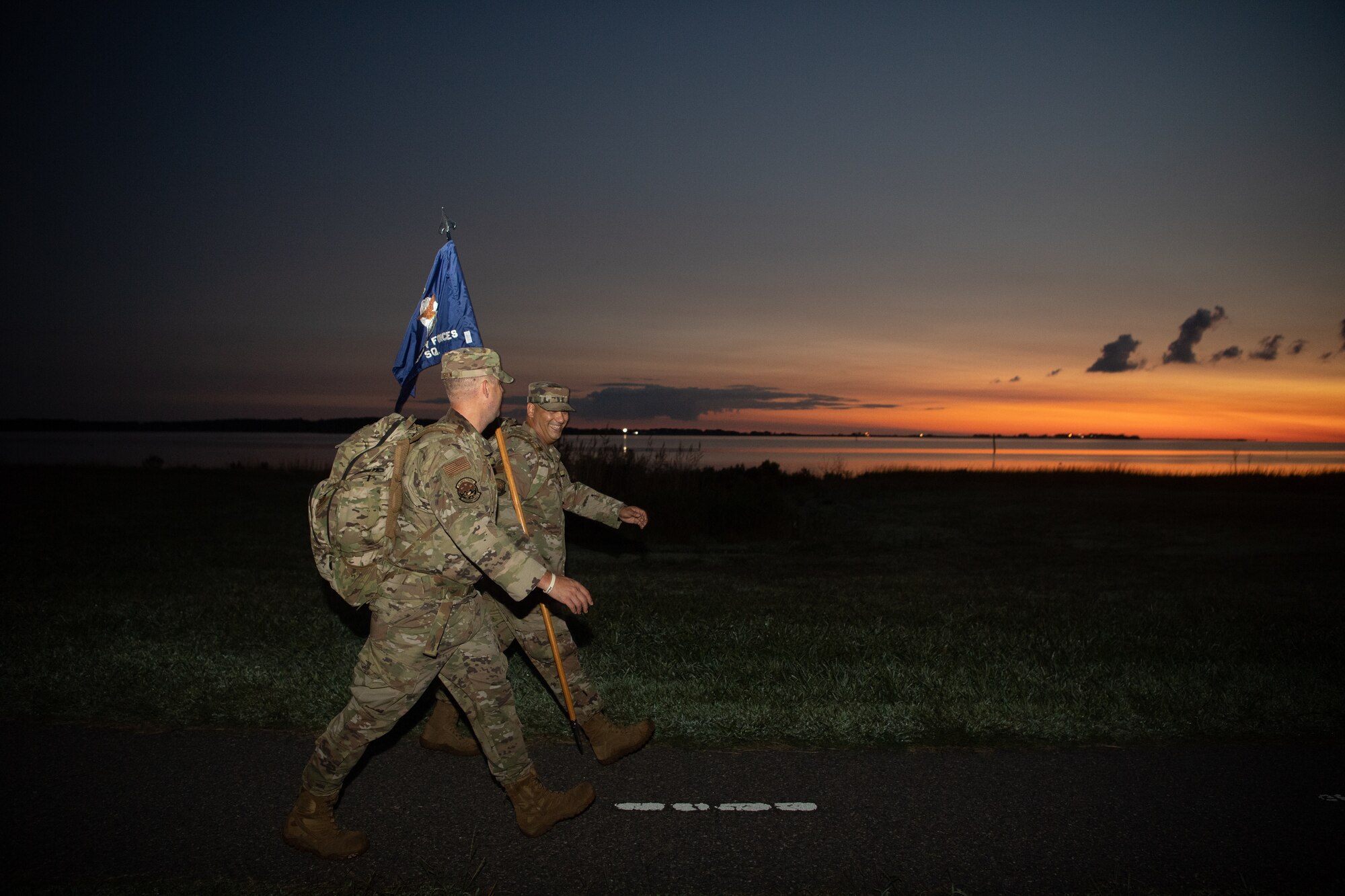 A group of Airmen walk and run outside in an event.