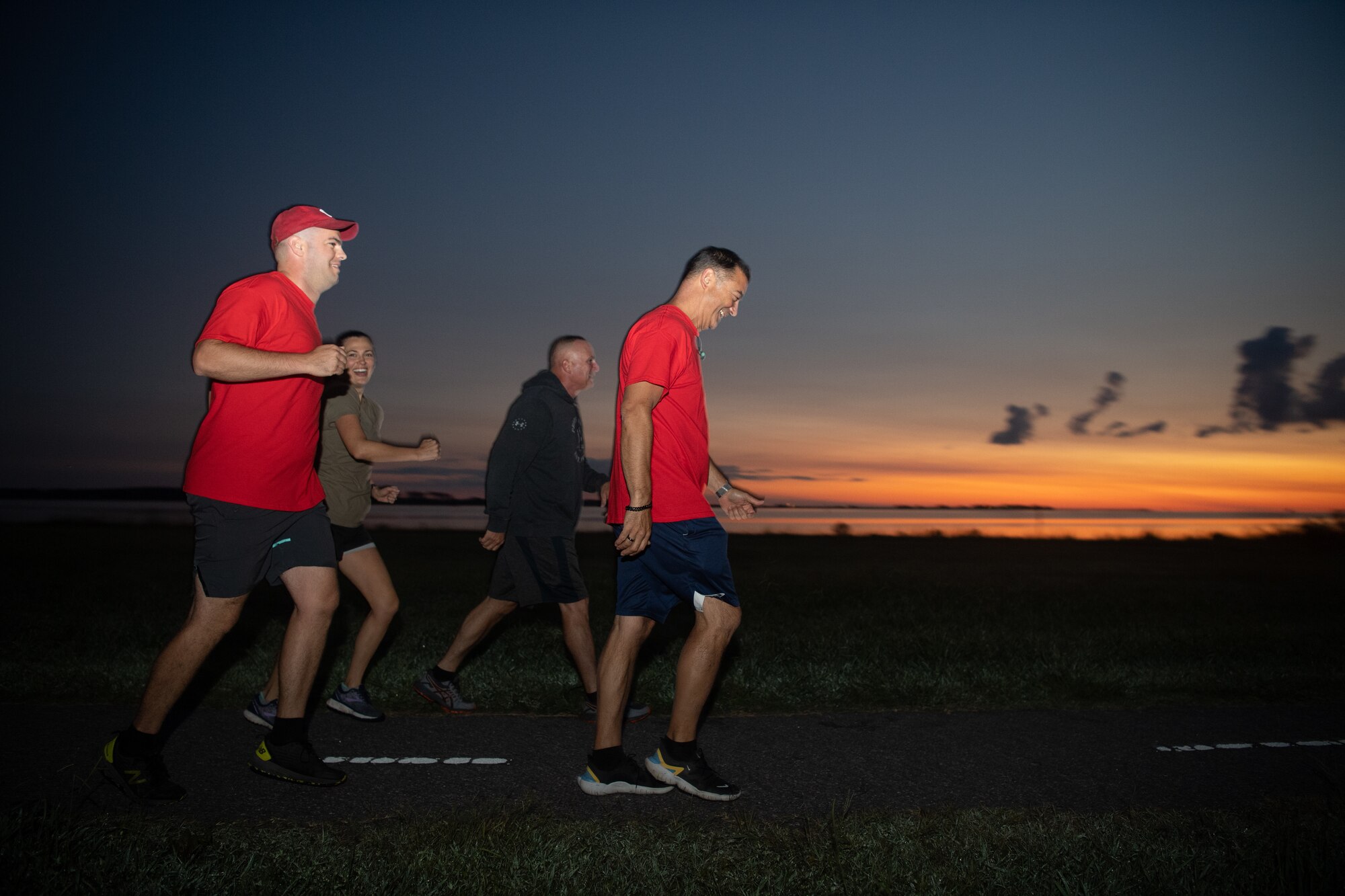 A group of Airmen walk and run outside in an event.