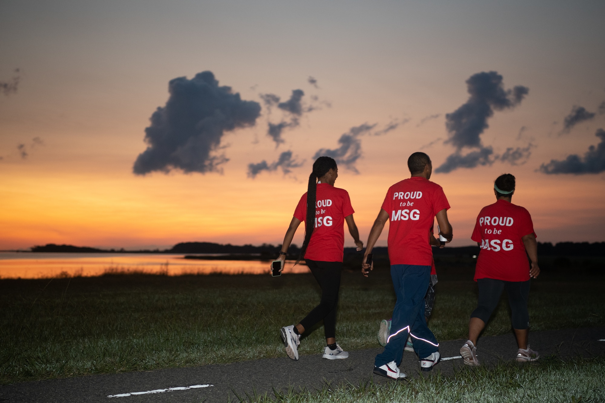 A group of Airmen walk and run outside in an event.
