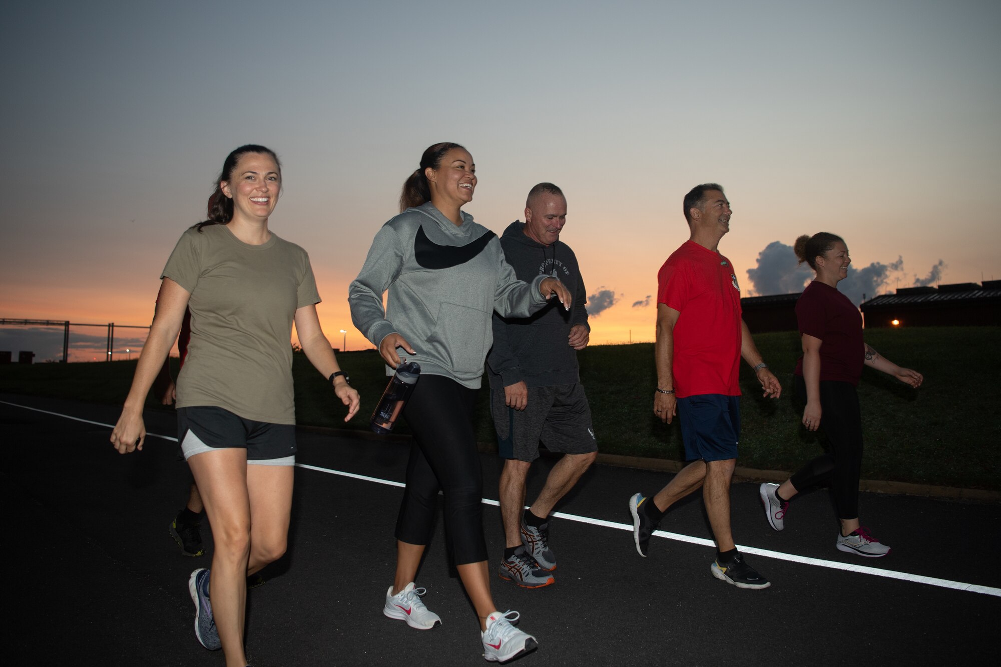 A group of Airmen run and walk in an event.