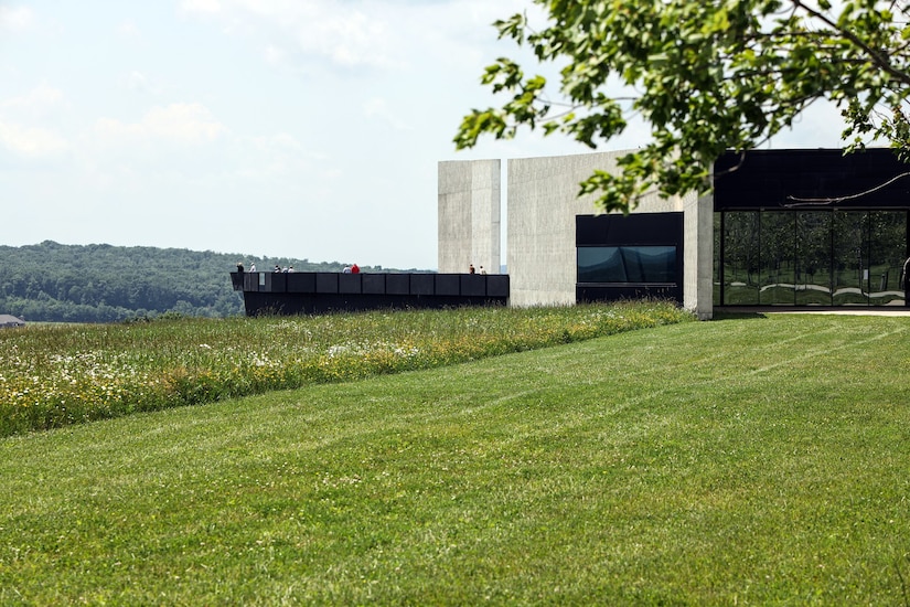 A memorial visitor center sits in the middle of a green field.