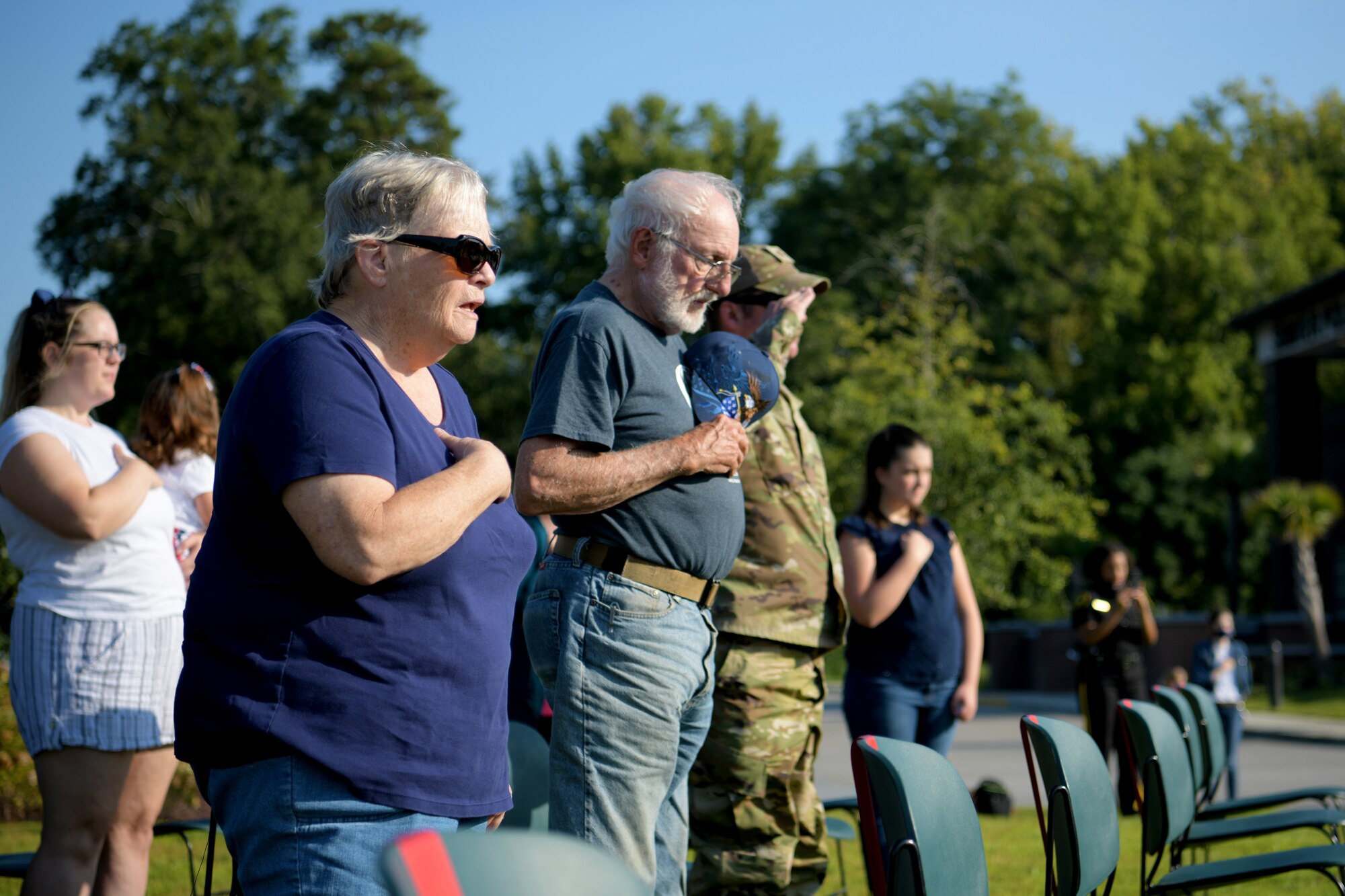 Susan Scouten, a resident of Sumter, left, sings along to the national anthem during a 9/11 memorial ceremony in Sumter, S.C., Sept. 11, 2021. The ceremony was held in remembrance of the 20th anniversary of the Sept. 11, 2001, attacks across the United States. (U.S. Air Force photo by Staff Sgt. K. Tucker Owen)